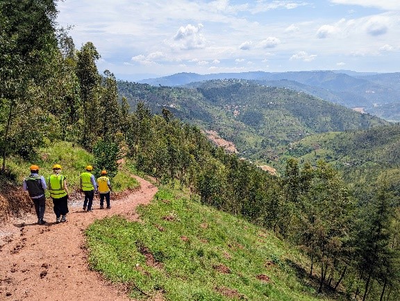 Workers in high visibility vests go down a mountain path