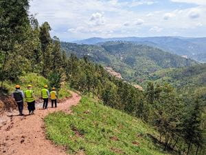 Workers in high visibility vests go down a mountain path Workers in high visibility vests go down a mountain path